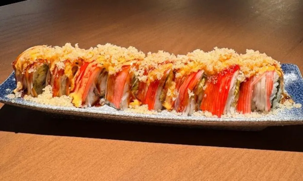 Crab stick sushi roll topped with crispy flakes and sauces at Machi Sushi, an Asian Restaurant in Houston
